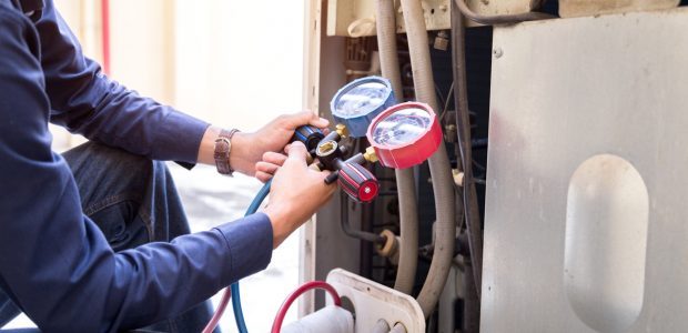 A skilled technician holding a pressure regulator gauge of a heating system